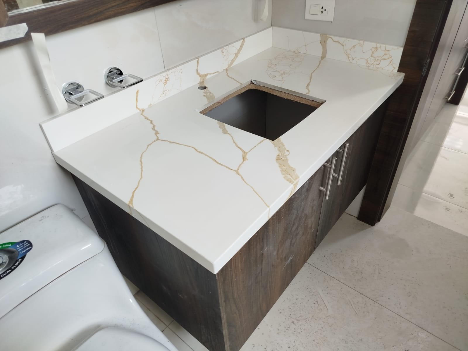 Mueble de baño con encimera de mármol blanco veteado — carpintería a medida en Quito por JOMAD